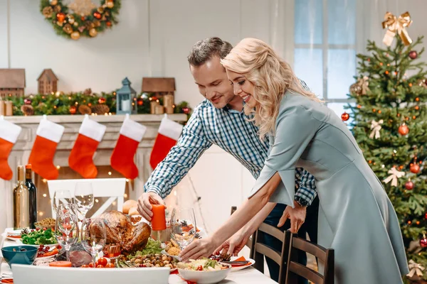 Pareja decorando mesa de Navidad - foto de stock