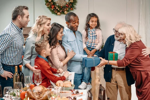 Grandparents presenting gifts to family — Stock Photo