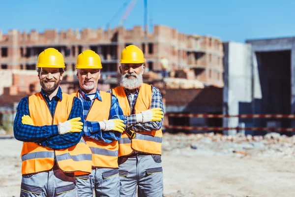 Three builders at construction site — Stock Photo