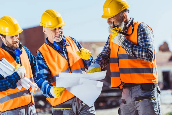 Construction workers examining building plans — Stock Photo