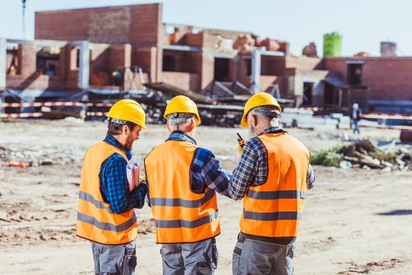 Three workers at construction site — Stock Photo