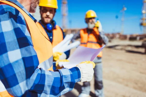 Travailleur du bâtiment examinant le plan du bâtiment — Photo de stock