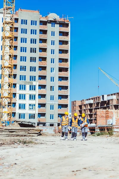 Три будівельники на будівельному майданчику — стокове фото