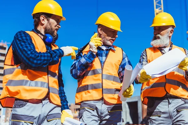 Três trabalhadores uniformizados no estaleiro de construção — Fotografia de Stock