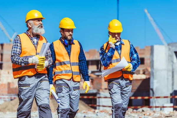 Three workers in hardhats at construction site — Stock Photo