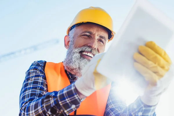 Travailleur de la construction utilisant une tablette numérique — Photo de stock