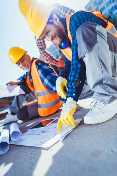 Trabalhadores da construção civil com planos de construção — Fotografia de Stock