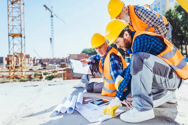 Trabajadores de la construcción mirando los planos de edificios - foto de stock