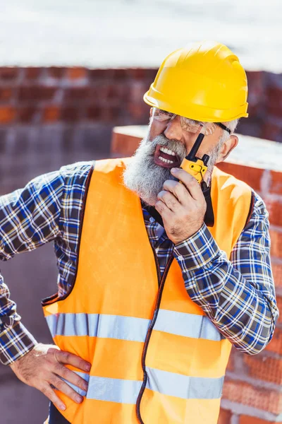 Travailleur de la construction parlant à la radio portable — Photo de stock