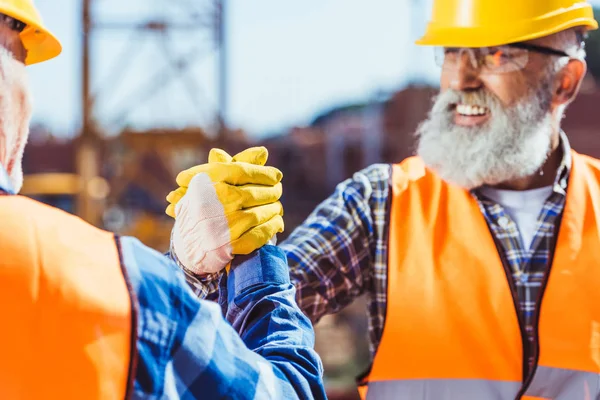Trabajadores de la construcción estrechando manos - foto de stock