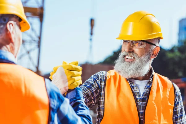 Construction workers shaking hands — Stock Photo