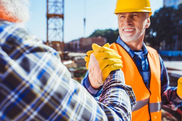 Construction workers shaking hands — Stock Photo