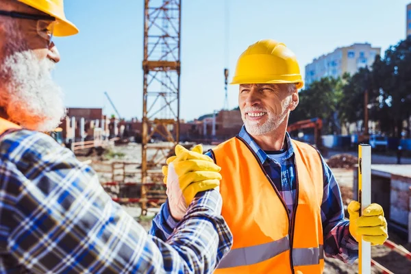 Trabajadores de la construcción estrechando manos - foto de stock