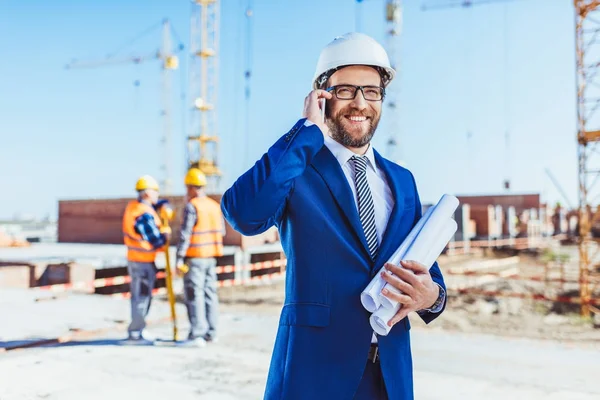 Businessman talking on phone at construction site — Stock Photo
