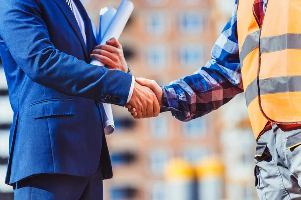Builder and businessman shaking hands — Stock Photo
