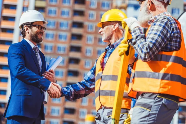 Будівельник і бізнесмен тремтять руками — стокове фото