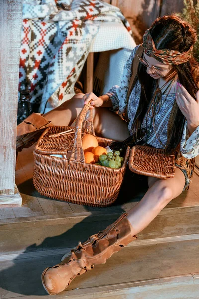 Bohème Frau blickt auf Korb mit Früchten — Stockfoto