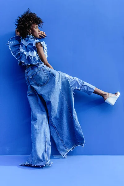 Африканская девушка позирует на голубом фоне — стоковое фото