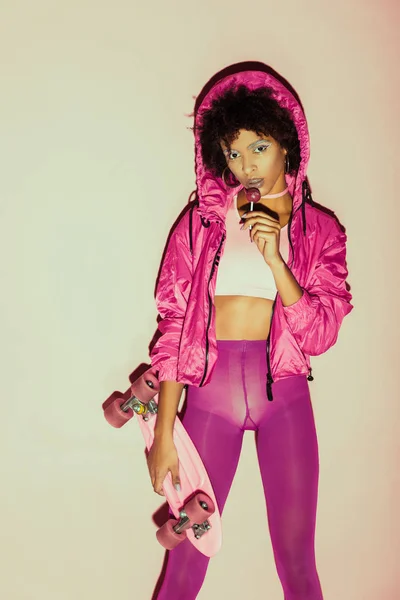 African american girl with penny board and lollipop — Stock Photo