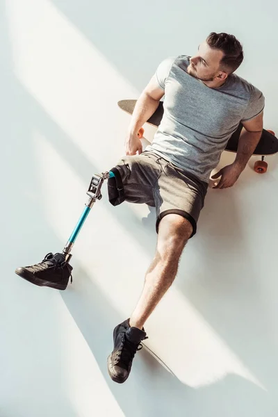 Homme avec prothèse de jambe reposant sur le skateboard — Photo de stock