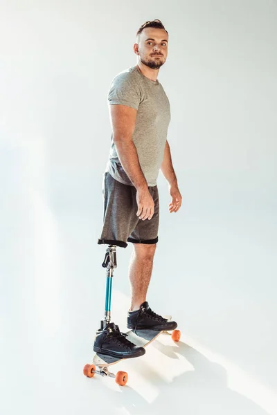 Homme avec prothèse de jambe debout sur skateboard — Photo de stock