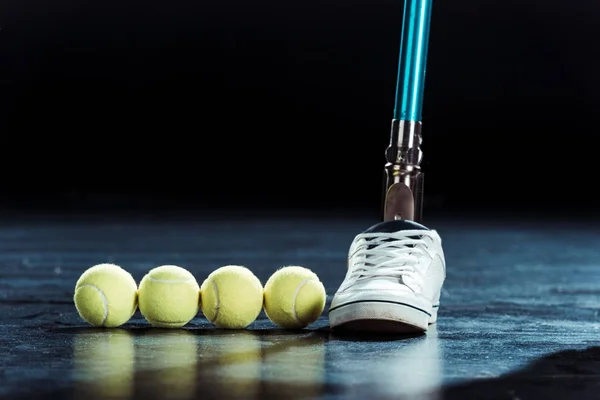 Leg prosthesis and tennis balls — Stock Photo