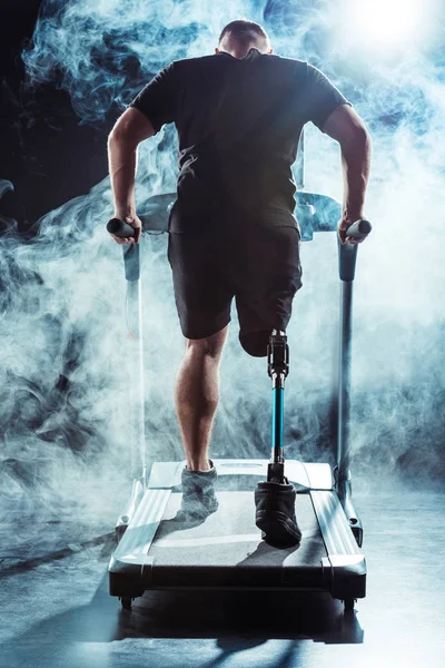 Sportsman with leg prosthesis training on treadmill — Stock Photo