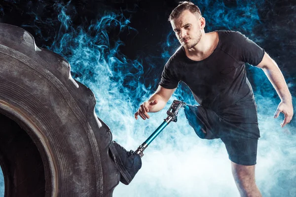 Paralympic sportsman standing at tire — Stock Photo