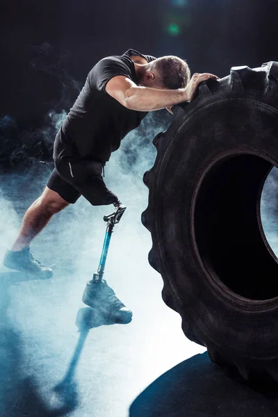 Paralympic sportsman pulling tire — Stock Photo