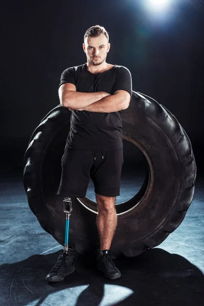 Atleta paralímpico apoiando-se no pneu — Fotografia de Stock
