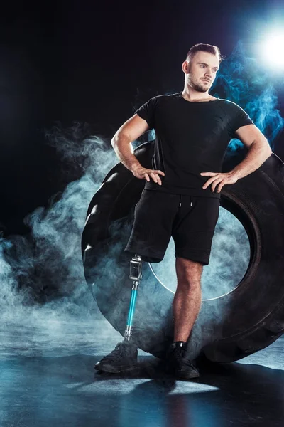 Paralympic sportsman leaning on tire — Stock Photo