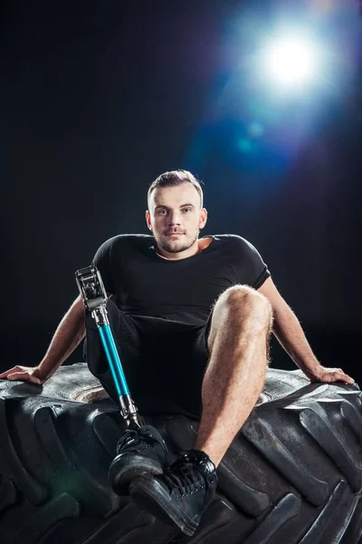 Paralympic sportsman resting on tire — Stock Photo