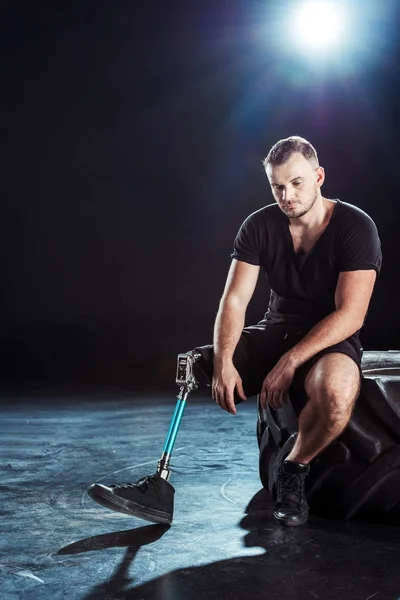 Paralympic sportsman resting on tire — Stock Photo