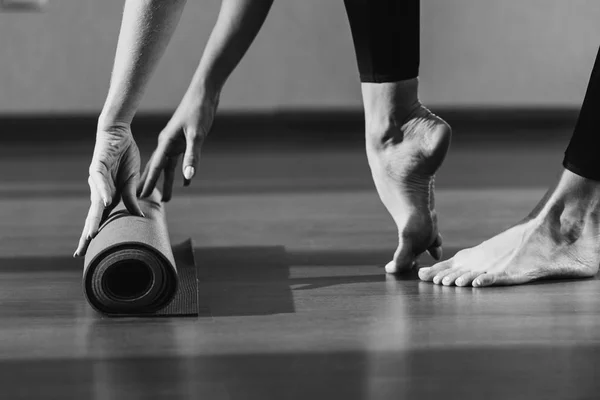 Femme déroulant tapis de yoga — Photo de stock