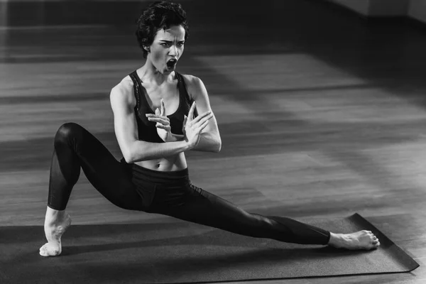 Shouting woman stretching on yoga mat — Stock Photo