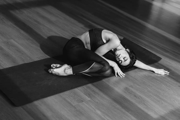 Mujer en ropa deportiva durmiendo en esterilla de yoga - foto de stock