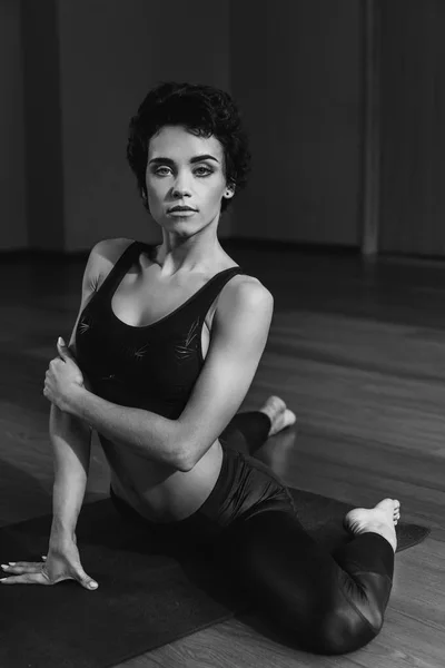 Woman sitting on yoga mat — Stock Photo