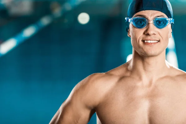 Улыбающийся мышечный пловец в плавательной шапке — стоковое фото