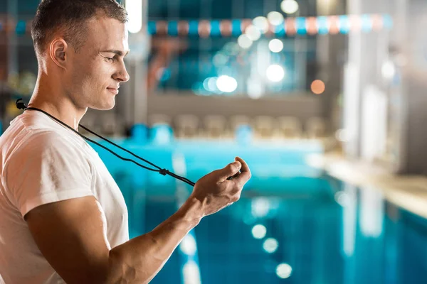 Entrenador con cronómetro en la piscina - foto de stock