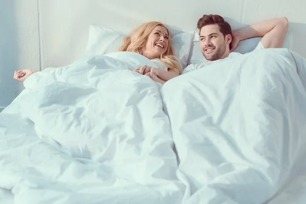 Casal relaxante na cama de manhã — Fotografia de Stock