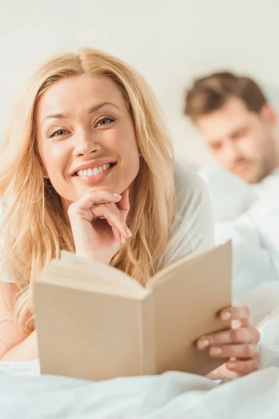 Mujer con libro en la cama — Stock Photo