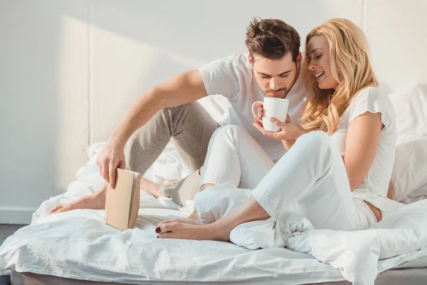Couple drinking coffee in bed — Stock Photo