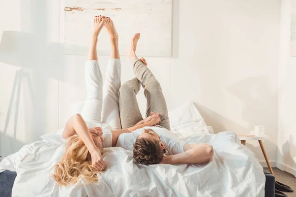 Pareja relajándose en la cama - foto de stock