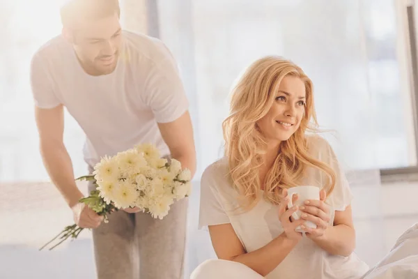 Homme présentant des fleurs pour petite amie — Photo de stock