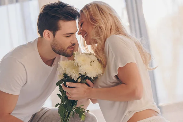 Homme présentant des fleurs pour petite amie — Photo de stock