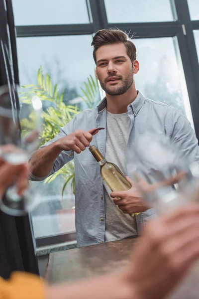 Hombre abriendo botella de vino para fecha - foto de stock