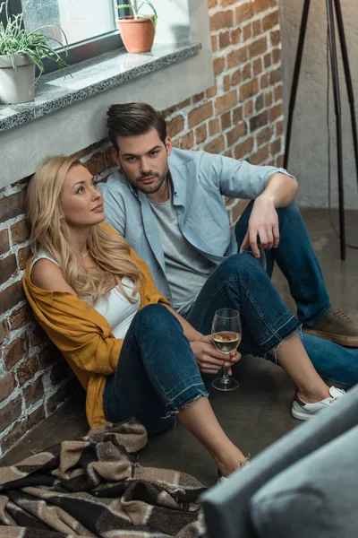 Pareja bebiendo vino en el suelo - foto de stock