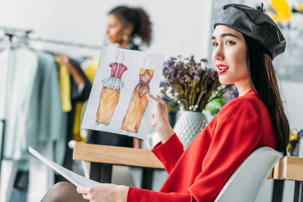 Asian fashion designer with sketches — Stock Photo
