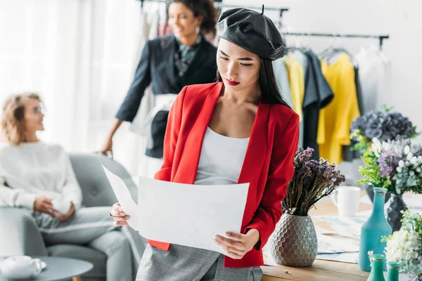 Asiático diseñador de moda con bocetos — Stock Photo