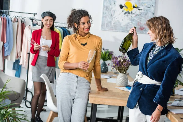 Fashion designers drinking champagne — Stock Photo